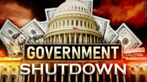 The U.S. Capitol with flying hundred-dollar bills in a dramatic orange background, featuring bold text reading "GOVERNMENT SHUTDOWN."