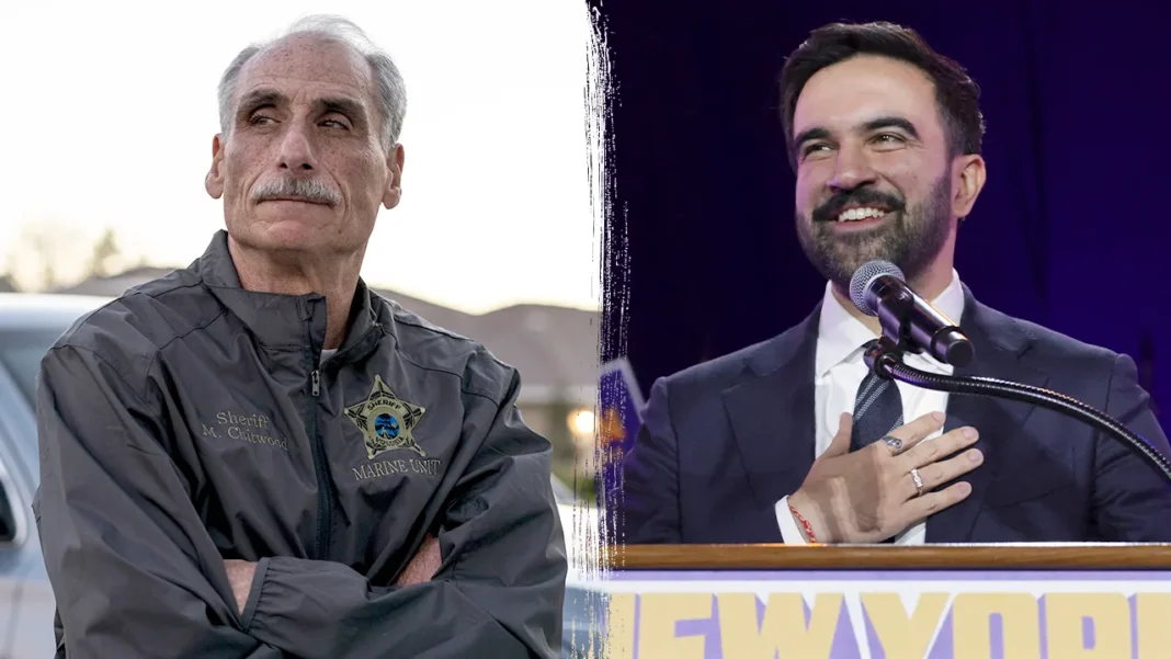 Florida Sheriff to New Yorkers After Mamdaniโs Win: โIt Can Be the Beginning of a New Lifeโ An elderly man in a sheriff's uniform looks serious outdoors, arms crossed. A bearded man in a suit smiles warmly at a podium indoors.