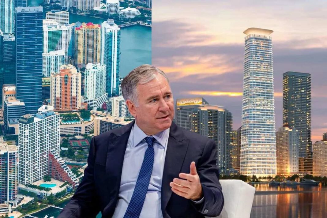 Billionaire Ken Griffin Accelerates Move to Florida, Sells Final Chicago Property at a Deep Discount A businessman gestures during an interview with a backdrop of Miami’s skyline, showcasing modern skyscrapers at sunset.
