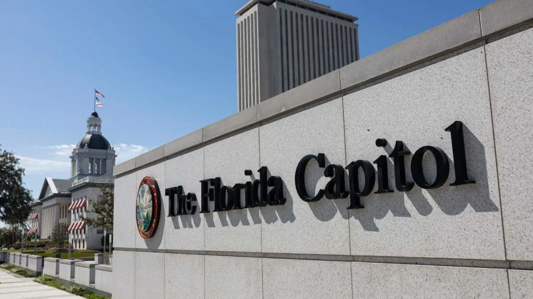 florida-capital-building-session-2026 The Florida Capitol building with its iconic dome and tower viewed from the side, featuring a sign reading 'The Florida Capitol' under a clear blue sky