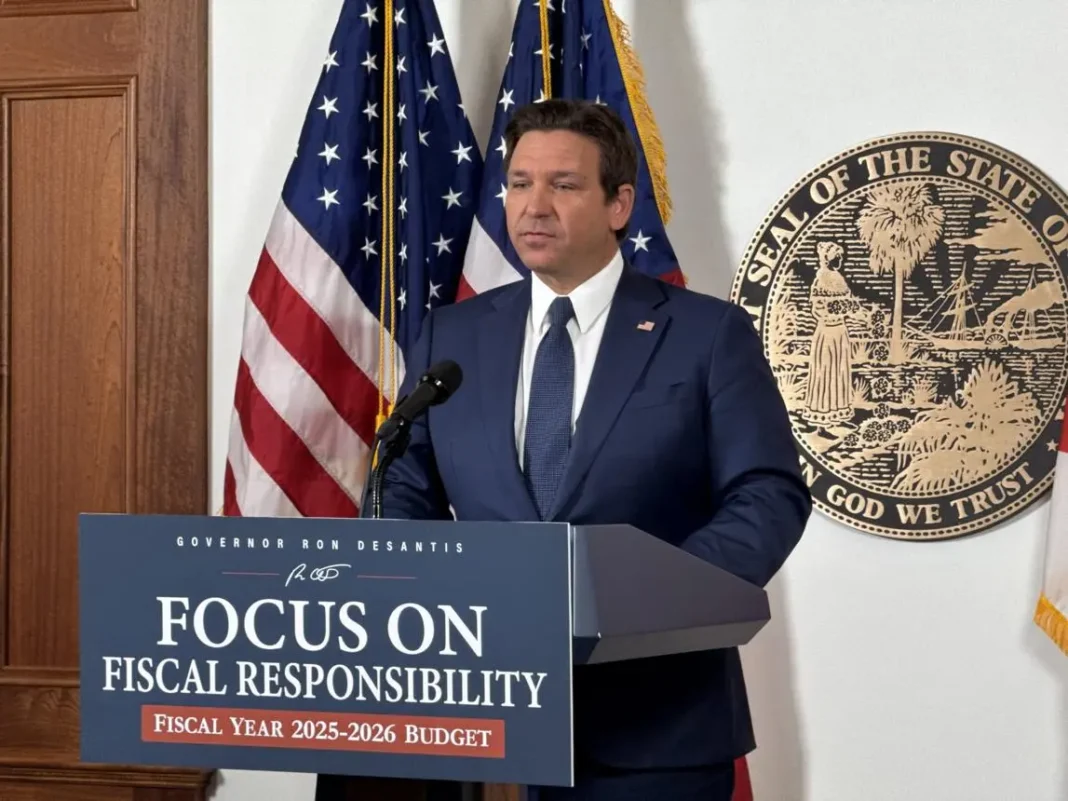 florida-budget-desantis-veto-114-billion-2026 Person in suit standing at podium with