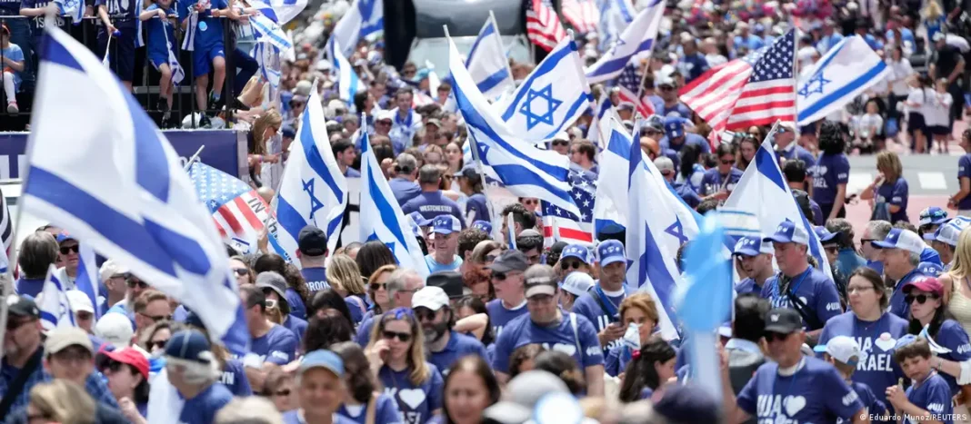 NYC Mayor Zohran Mamdani Skips Israel Day Parade, Breaking Longstanding Political Tradition Crowd of people wearing blue and white, waving Israeli and American flags, participating in a public event