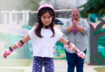 Judge Rejects Bid to Force Florida to Implement Long-Delayed KidCare Expansion A child wearing protective gear roller-skates while an adult watches and applauds.
